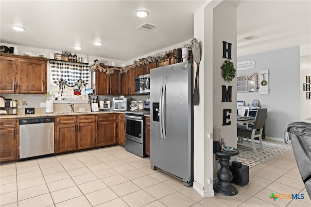 1037 Declaration Dr, Copperas Cove, TX 76522 - kitchen featuring appliances with stainless steel finishes, light tile patterned floors, light stone countertops, backsplash, and recessed lighting