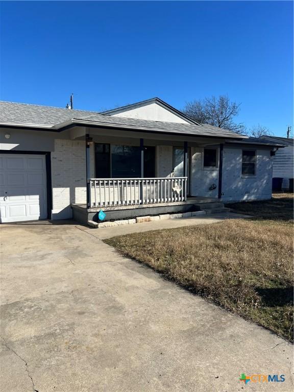 ranch-style house featuring a garage and covered porch