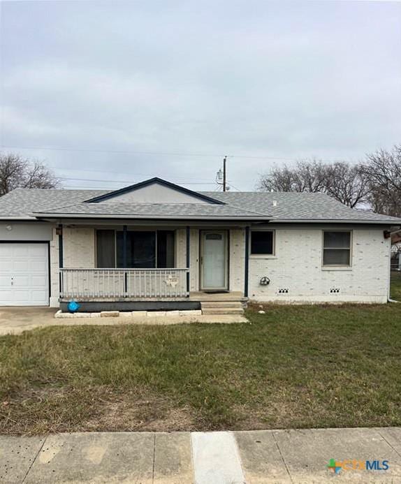 ranch-style home featuring covered porch, a garage, and a front yard