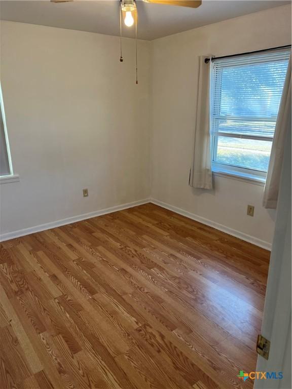 spare room with hardwood / wood-style flooring and ceiling fan