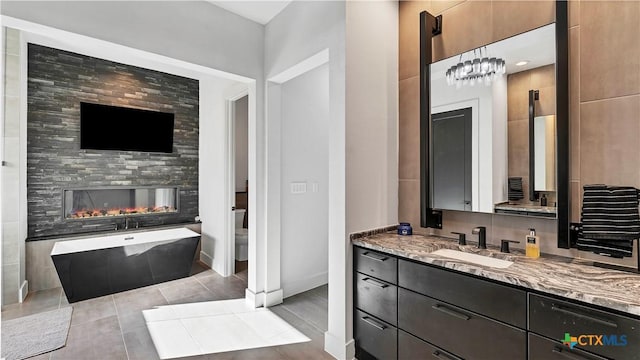 bathroom featuring vanity, a bath, tile patterned flooring, and a multi sided fireplace