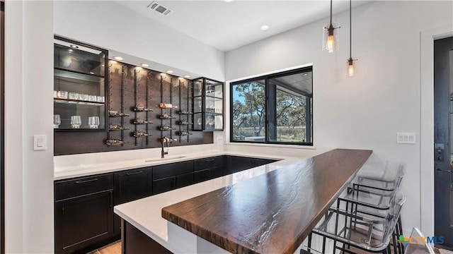 bar featuring sink and pendant lighting