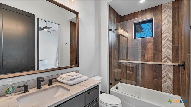 full bathroom with vanity, ceiling fan, toilet, and tiled shower / bath