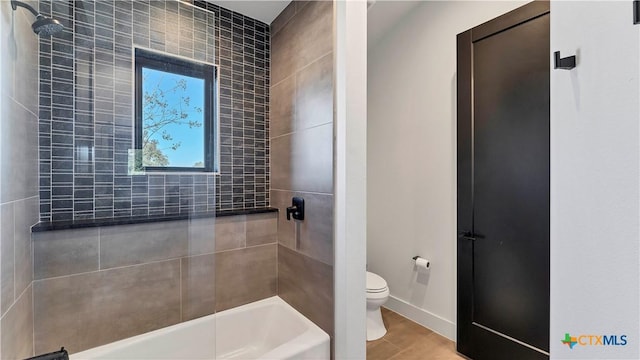 bathroom with tiled shower / bath and toilet