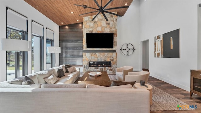 living room featuring high vaulted ceiling, a fireplace, wooden ceiling, and wood-type flooring