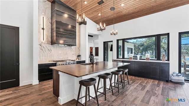 kitchen featuring dark hardwood / wood-style floors, pendant lighting, sink, a center island with sink, and wooden ceiling