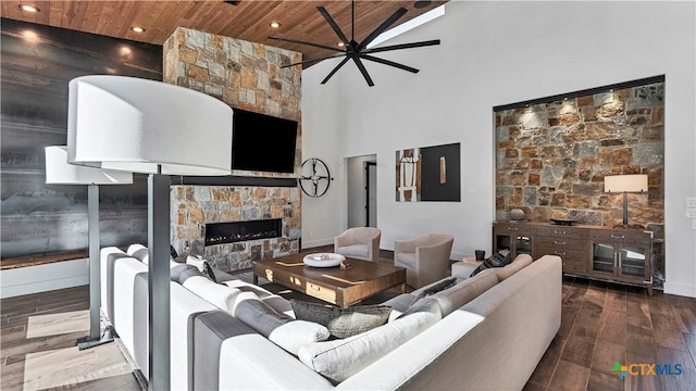 living room featuring a stone fireplace, high vaulted ceiling, wooden ceiling, ceiling fan, and hardwood / wood-style floors