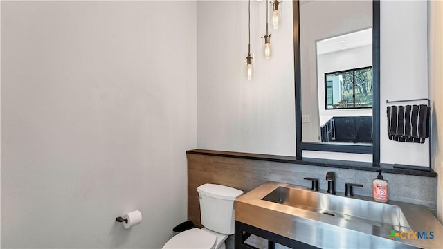 bathroom with tasteful backsplash, vanity, and toilet