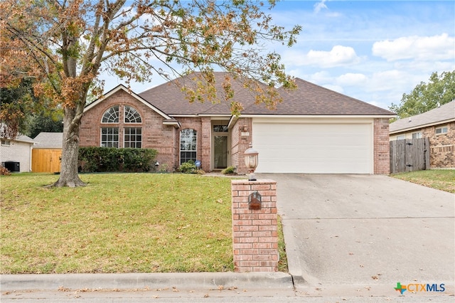 view of front facade with a front yard, a garage, and central AC unit