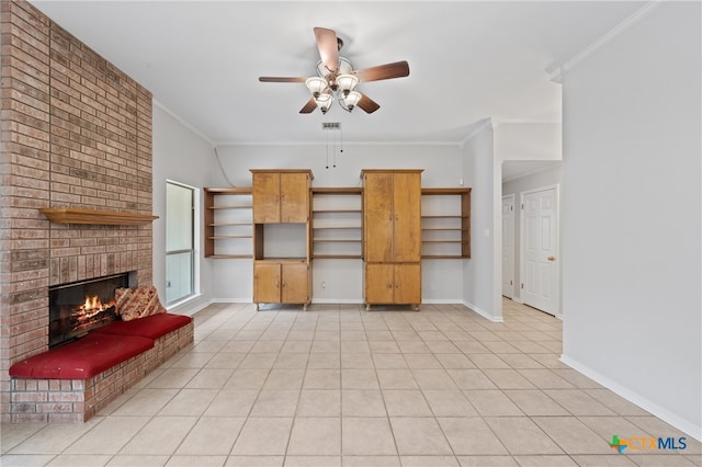 unfurnished living room featuring a fireplace, ceiling fan, crown molding, and light tile patterned flooring