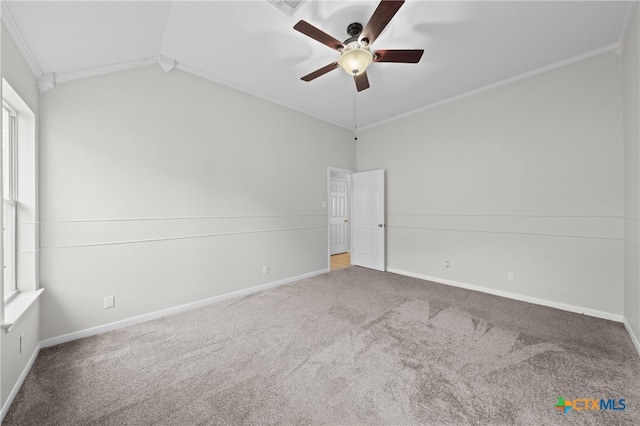 empty room with carpet, vaulted ceiling, ceiling fan, and crown molding