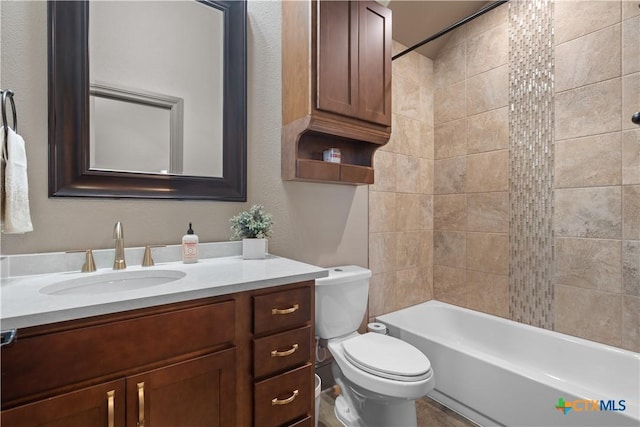 full bathroom with vanity, tiled shower / bath combo, and toilet