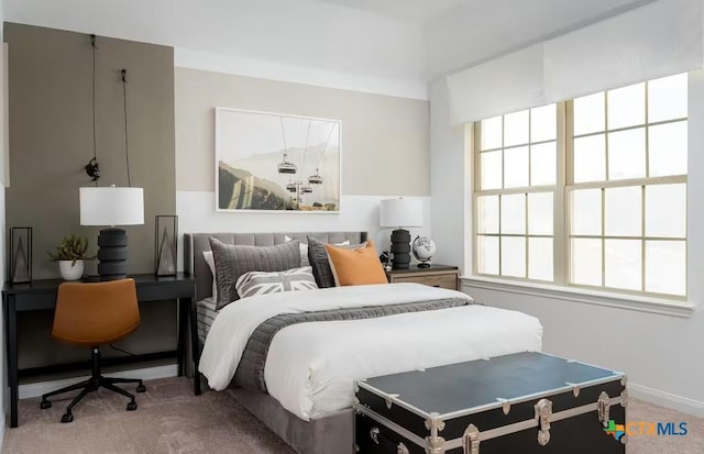 bedroom with light colored carpet and baseboards