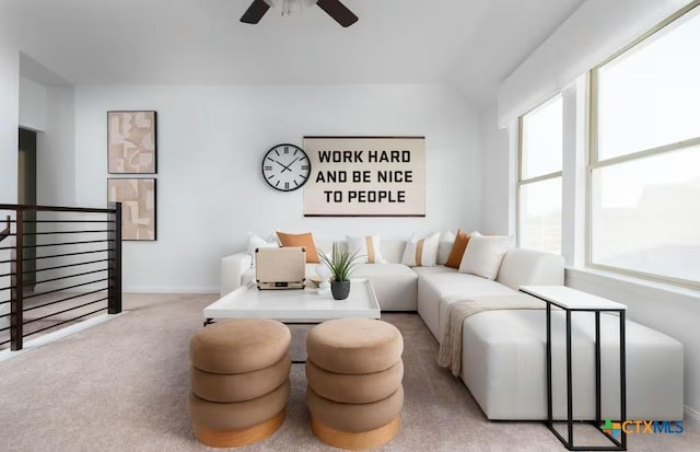 carpeted living area featuring baseboards, a ceiling fan, and lofted ceiling