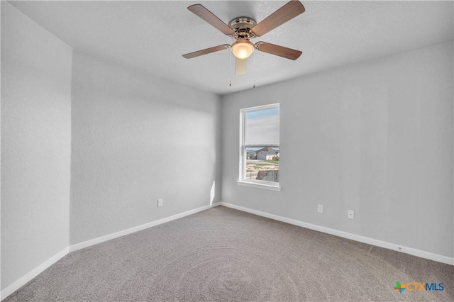 empty room with carpet, baseboards, and ceiling fan