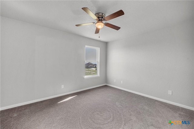 carpeted empty room with baseboards and a ceiling fan