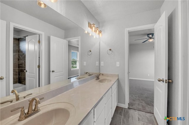 bathroom featuring double vanity, baseboards, a sink, and ceiling fan