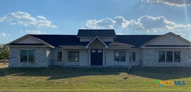 view of front of home featuring a front yard and stone siding