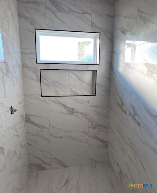 bathroom with a marble finish shower