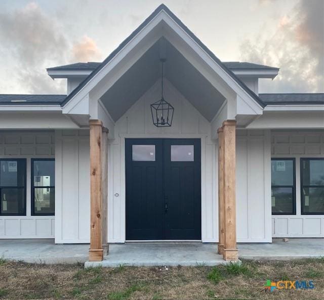 doorway to property with board and batten siding and covered porch