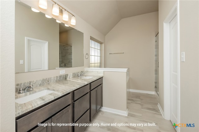 bathroom with hardwood / wood-style floors, walk in shower, vanity, and vaulted ceiling