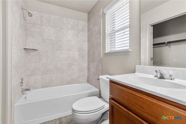 full bathroom with tiled shower / bath, vanity, and toilet