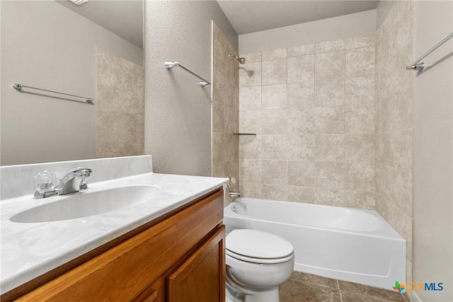 full bathroom featuring tiled shower / bath combo, vanity, tile patterned flooring, and toilet