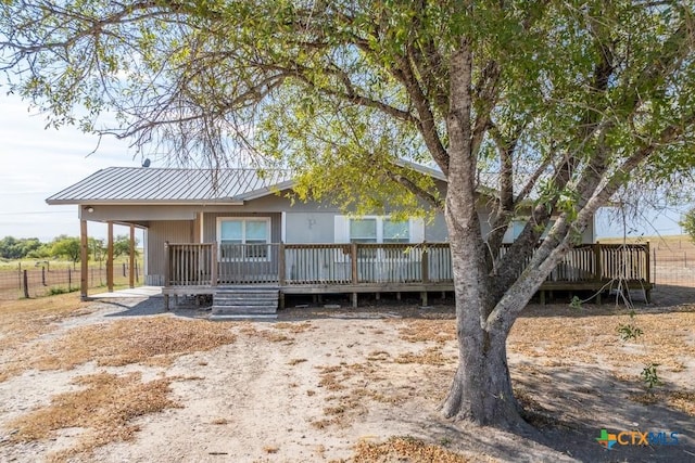 3300 State Highway 95, Shiner, TX 77984 - view of front of home with metal roof, fence, and a wooden deck