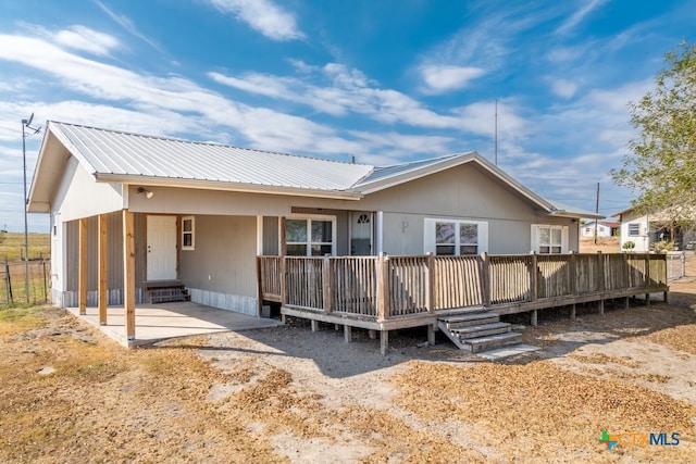 rear view of property featuring a carport and a deck