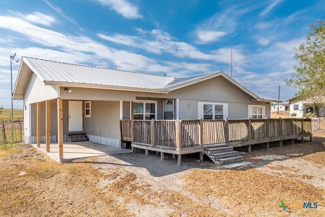 3300 State Highway 95, Shiner, TX 77984 - rear view of house featuring an attached carport, metal roof, a wooden deck, and a patio area