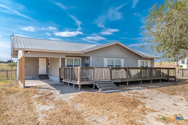 rear view of house featuring a wooden deck