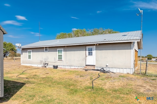 rear view of property featuring a lawn