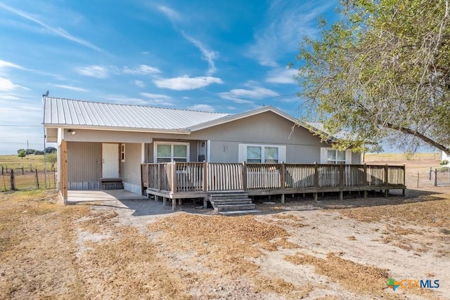 3300 State Highway 95, Shiner, TX 77984 - view of front of home featuring fence, metal roof, and a wooden deck