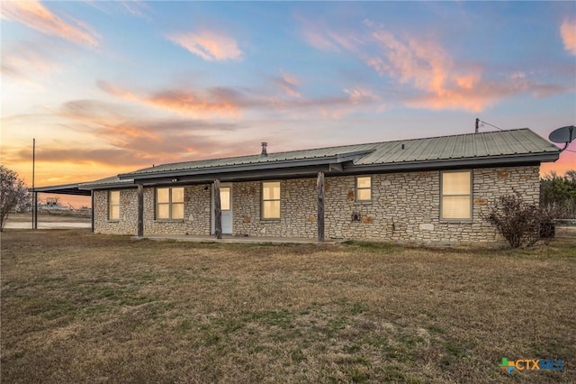 back house at dusk with a lawn