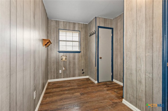 interior space featuring wooden walls, hookup for an electric dryer, and dark hardwood / wood-style flooring