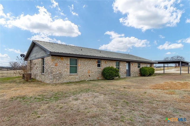 view of side of home with a carport and a yard