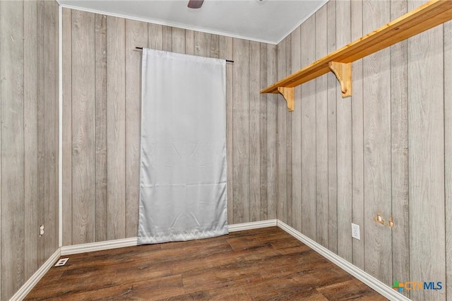 unfurnished room featuring ceiling fan, wooden walls, and dark hardwood / wood-style flooring