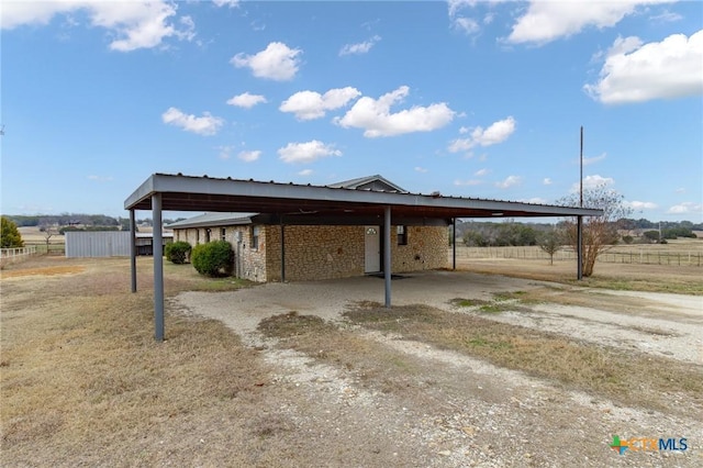 view of parking with a carport and a rural view