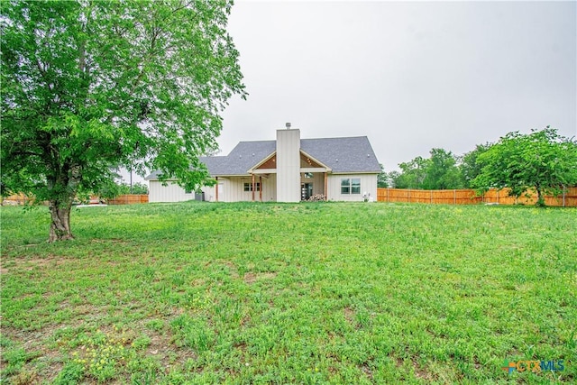 6864 Moffat Loop, Temple, TX 76502 - back of house featuring a lawn, fence, a chimney, and board and batten siding