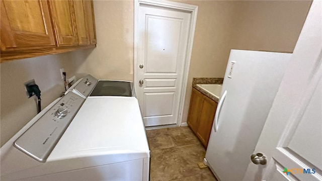 laundry area with light tile patterned flooring, cabinets, sink, and washer and dryer