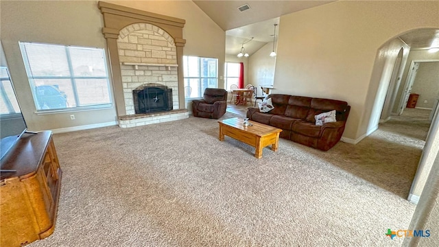 living room featuring a stone fireplace, high vaulted ceiling, and carpet