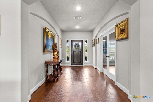 foyer entrance featuring dark hardwood / wood-style flooring and a textured ceiling