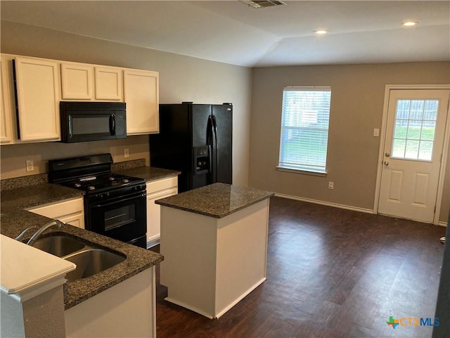 kitchen with sink, a center island, white cabinetry, and black appliances