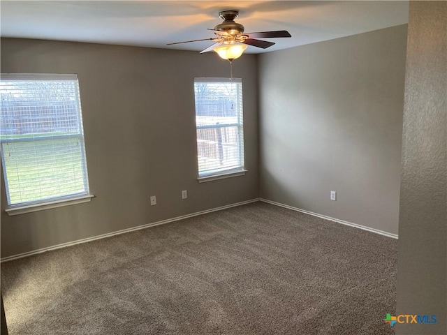 carpeted spare room featuring ceiling fan