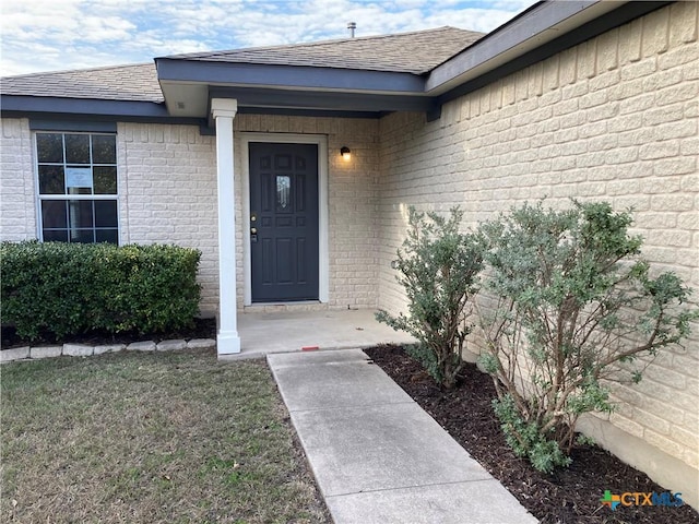 property entrance with a lawn