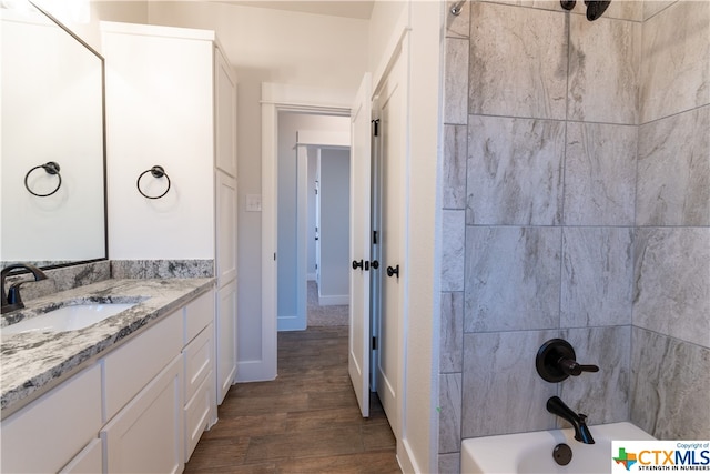 bathroom featuring tiled shower / bath combo, vanity, and hardwood / wood-style flooring