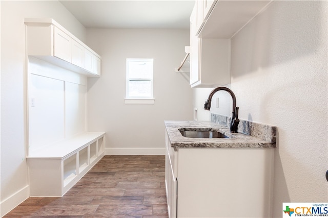 laundry area with cabinets, sink, and light hardwood / wood-style floors