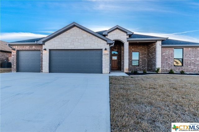 ranch-style home with a garage and a front lawn