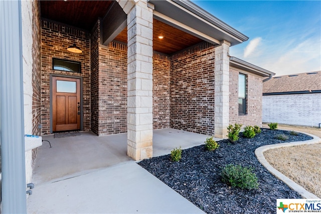 view of exterior entry with a patio