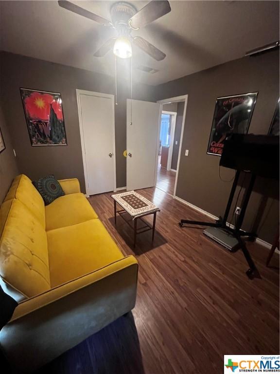 living room featuring ceiling fan and wood-type flooring